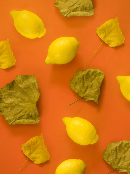 Patrón de limones y hojas de otoño sobre fondo naranja —  Fotos de Stock