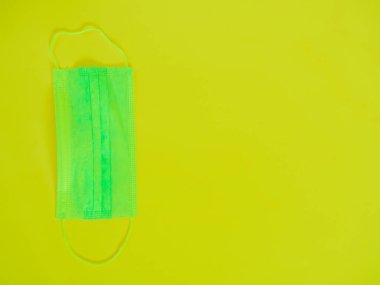 Sarı arka planda yeşil hijyenik maske ve fotokopi spac