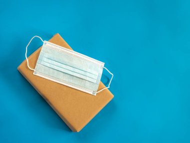Maskeli paket mavi arkaplanda kopyalama alanı ile - güvenli teslim konsepti