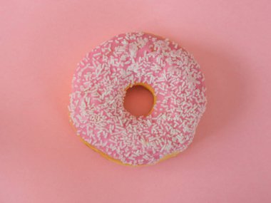 Pembe arka planda beyaz serpiştirilmiş pembe çörekler.