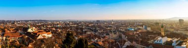 Graz, Styria / Avusturya - 20.01.2019: Graz City, şehir rooftops, Mur nehir ve şehir merkezi, Schlossberg tepesi ve saat kulesi güneş kış, mavi gökyüzünde geniş Panoraması. Seyahat hedef.