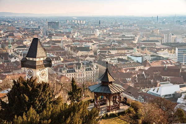 Graz, Styria / Avusturya - 20.01.2019: Graz City Schlossberg hill, şehir rooftops, Mur nehir ve şehir merkezi, saat kulesi güneş manzaraya kış mavi gökyüzü üzerinde. Seyahat hedef.