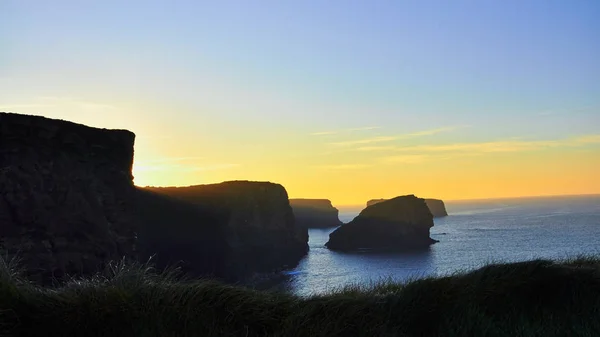 Falésias de Kilkee na Irlanda Condado de Clare durante o pôr do sol. Turista — Fotografia de Stock