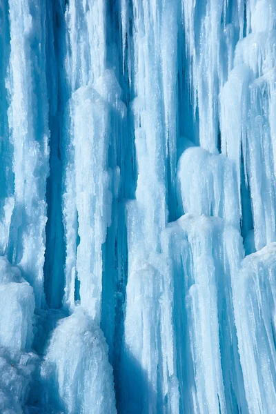Large icicles hang from river bank cliff.
