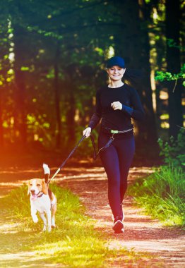 Ormanda bir yolda doğada beagle köpek açık havada yürüyüş Kız.