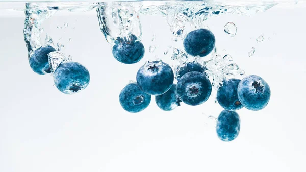 蓝莓在水晶般清澈的水中喷出气泡 — 图库照片