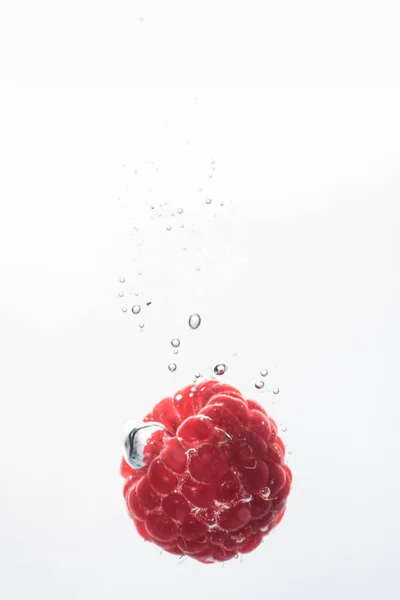 Raspberry falling into a water — Stock Photo, Image