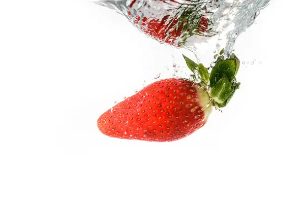 Strawberry splashing into crystal water — Stock Photo, Image