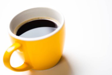 Beyaz arka planda sarı seramik kahve espresso bardağı