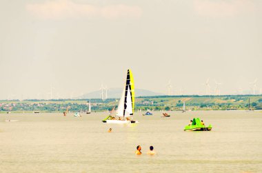 Ünlü Neusiedl Gölü, Burgenland, insanlar yüzme, tekneler gölde yelken.