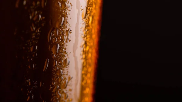 Glass of beer with foam on black background closeup — Stock Photo, Image