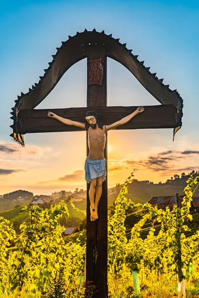 Christliches Holzkreuz mit Jesusfigur auf Weinbergen an der slowenisch-österreichischen Grenze — Stockfoto