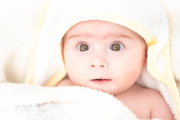 Entzückendes kleines Mädchen nach dem Bad in Handtuch gewickelt. mit großen braunen Augen aufblicken. Kopierraum — Stockfoto