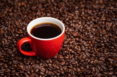 Kahve çekirdeği kaplı kırmızı kahve fincanı. Boşluk arkaplanı kopyala