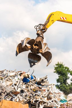 Close-up of a crane for recycling metallic waste on scrapyard clipart