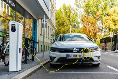 Graz, Avusturya - 24.06.2020: Modern elektrikli arabalar EV Car şarj istasyonuna takıldı. Yeni enerji araçları, arabalar için çevre dostu alternatif enerji