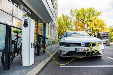 Graz, Avusturya - 24.06.2020: Modern elektrikli arabalar EV Car şarj istasyonuna takıldı. Yeni enerji araçları, arabalar için çevre dostu alternatif enerji