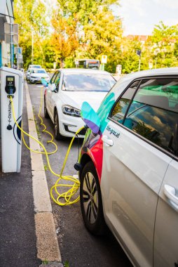 Graz, Avusturya - 24.06.2020: Modern elektrikli arabalar EV Car şarj istasyonuna takıldı. Yeni enerji araçları, arabalar için çevre dostu alternatif enerji