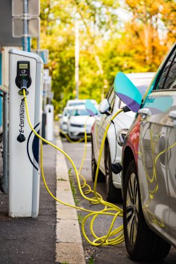 Graz, Avusturya - 24.06.2020: Modern elektrikli arabalar EV Car şarj istasyonuna takıldı. Yeni enerji araçları, arabalar için çevre dostu alternatif enerji