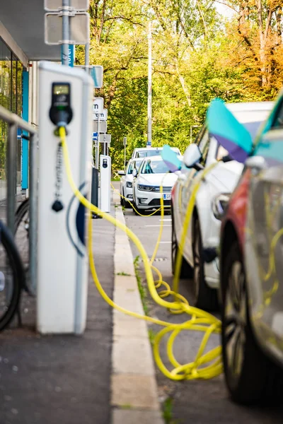 Graz, Avusturya - 24.06.2020: Modern elektrikli arabalar EV Car şarj istasyonuna takıldı. Yeni enerji araçları, arabalar için çevre dostu alternatif enerji
