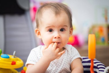 Bir yaşındaki bir bebek renkli eğitim programlarıyla Walker 'da oturuyor. Çocuk gelişimi kavramı
