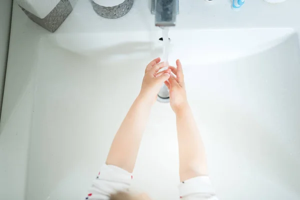Nettes kleines Mädchen 2-3 Jahre alt Hände waschen mit Seife und Wasser im hellen Badezimmer. Ansicht von oben — Stockfoto