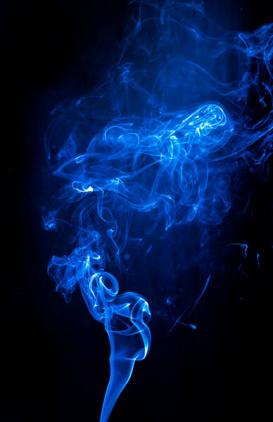 Blue abstract shaped smoke against black background. Abstract background. Selective focus