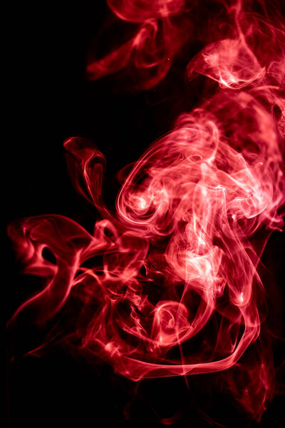 Red abstract shaped smoke against black background. Abstract background. Selective focus