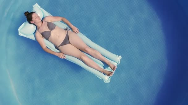Молодая женщина в бикини на коврике Air Mat Mattress в круглом наземном бассейне. — стоковое видео