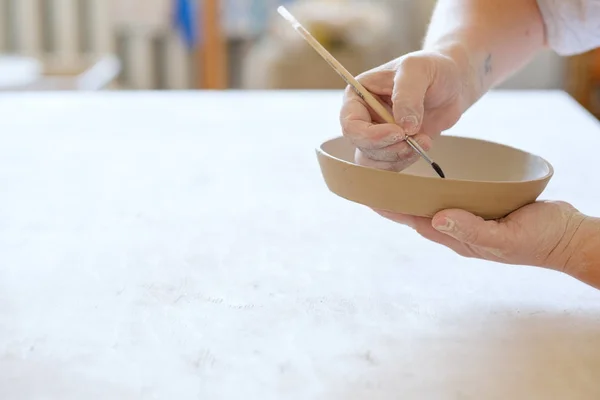 Керамічна майстерня фарбує глиняну тарілку ручної роботи посуд — стокове фото