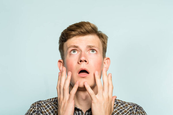 изумленный ошеломленный, ошеломленный человек смотрит вверх
