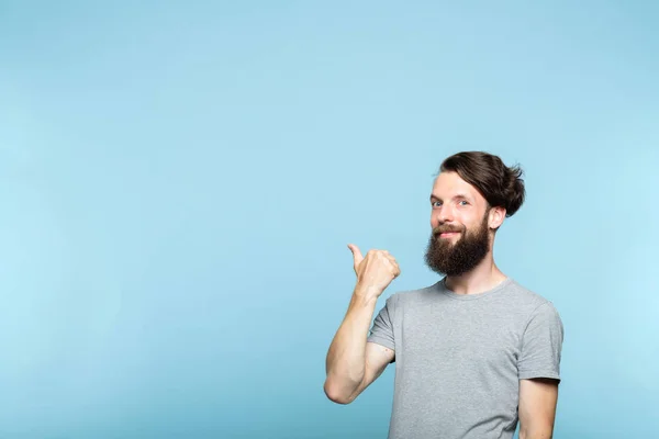 Усміхнений чоловік вказує рекламу бородатого хіпстера — стокове фото