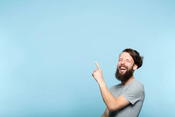 Сміється чоловік вказує на рекламу бородатого хіпстера — стокове фото