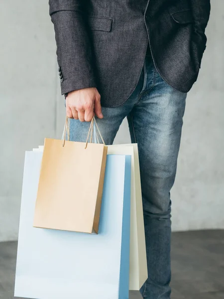 Tatil alışveriş adam tutun birden çok çanta sunar — Stok fotoğraf