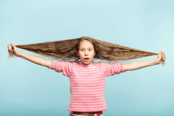 Уход за волосами шокированные девушка держать длинные волнистые волосы — стоковое фото