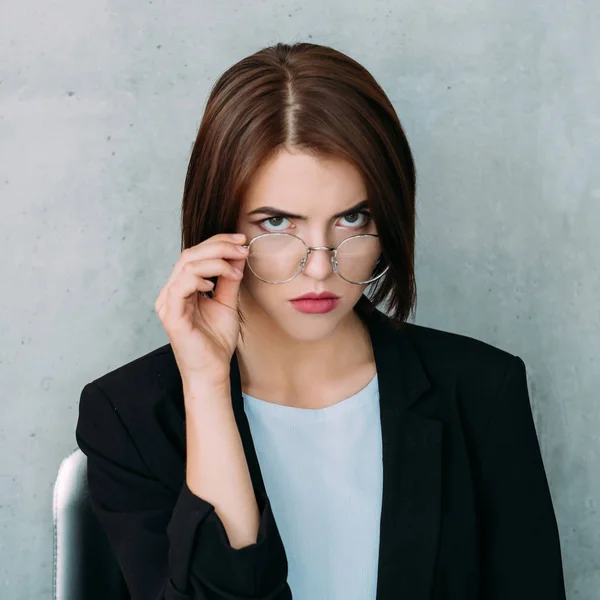 Mujer de negocios gruñón serio mirando gafas — Foto de Stock