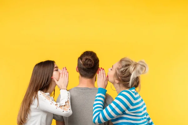 Back view teenage women whisper secrets man yellow — Stock Photo, Image