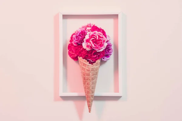 Presente conceitual cravo rosa moldura cone creme — Fotografia de Stock