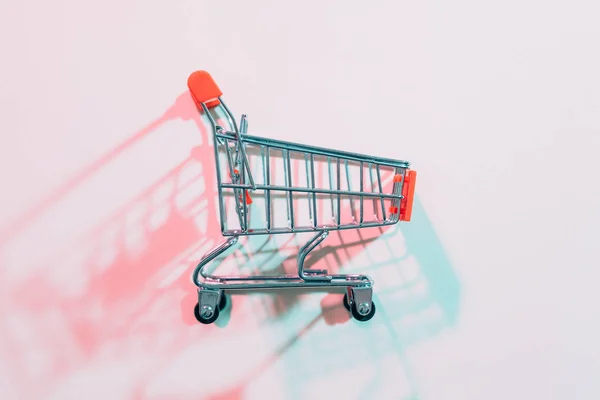 Consumismo vacío carrito de la compra rojo sombra — Foto de Stock