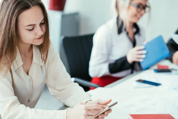 Gelangweilte Arbeitskollegen schlummern im Smartphone — Stockfoto