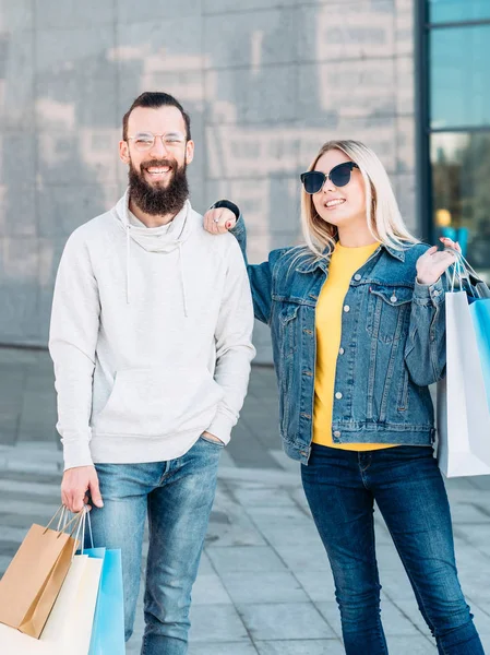 Joven compras pareja urbano consumismo bolsas de papel — Foto de Stock