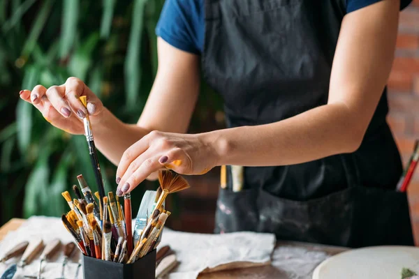 Artista fornece obras de arte estúdio mulher local de trabalho — Fotografia de Stock