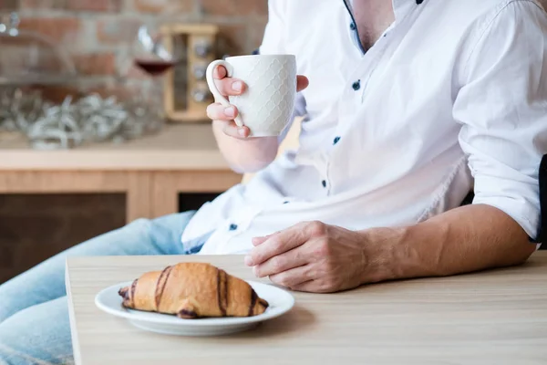 Ochtend gezelligheid thuis ontbijt man cup croissant — Stockfoto