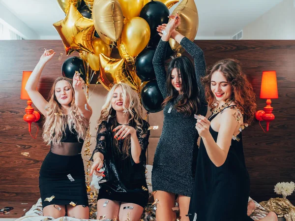 Lányok zsiványtanya szórakoztató tánc ágy party léggömbök — Stock Fotó