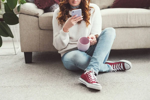 Kız eğlence rahat ev fincan tarama akıllı telefon — Stok fotoğraf
