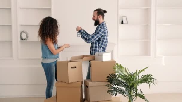 Movendo para casa feliz jovem casal sala de decoração — Vídeo de Stock