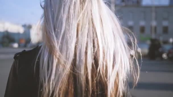 Женщина ходит по улице волосы дуют ветром солнцезащитные очки — стоковое видео