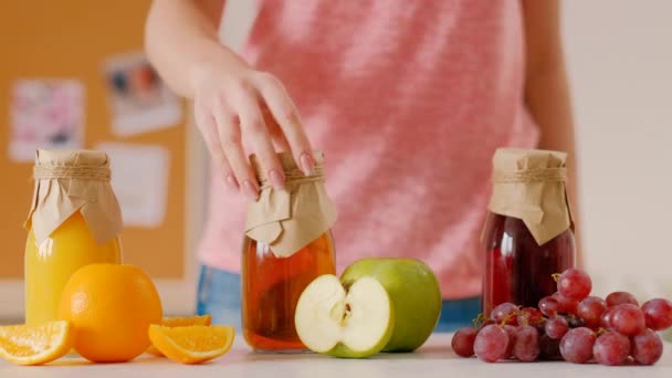 Vrouw flessen vers sap fruit kiezen oranje — Stockvideo