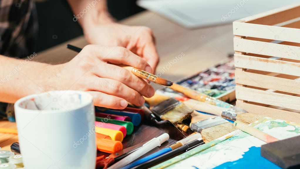 artist tools paintbrushes markers hands workplace