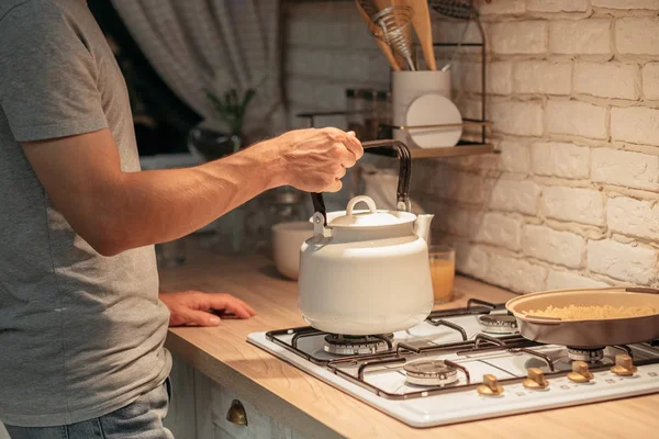 Tarde da noite chá hábito homem colocando fogão chaleira — Fotografia de Stock